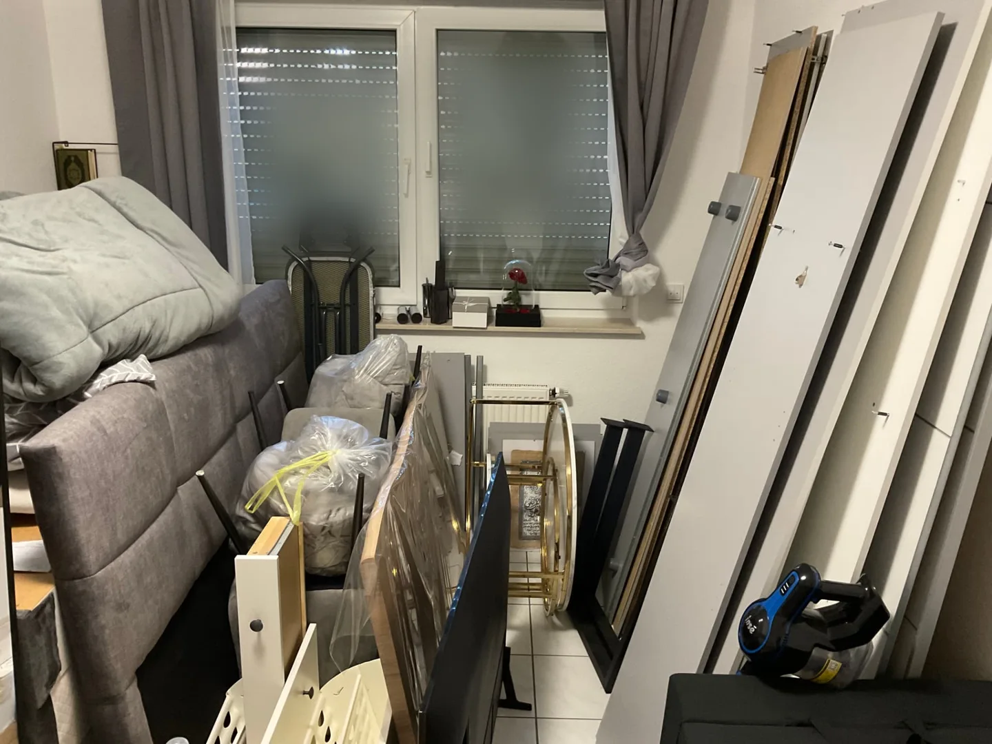 Schlafzimmer der Erdgeschosswohnung mit Bett und Hausrat zu Beginn des Auftrags