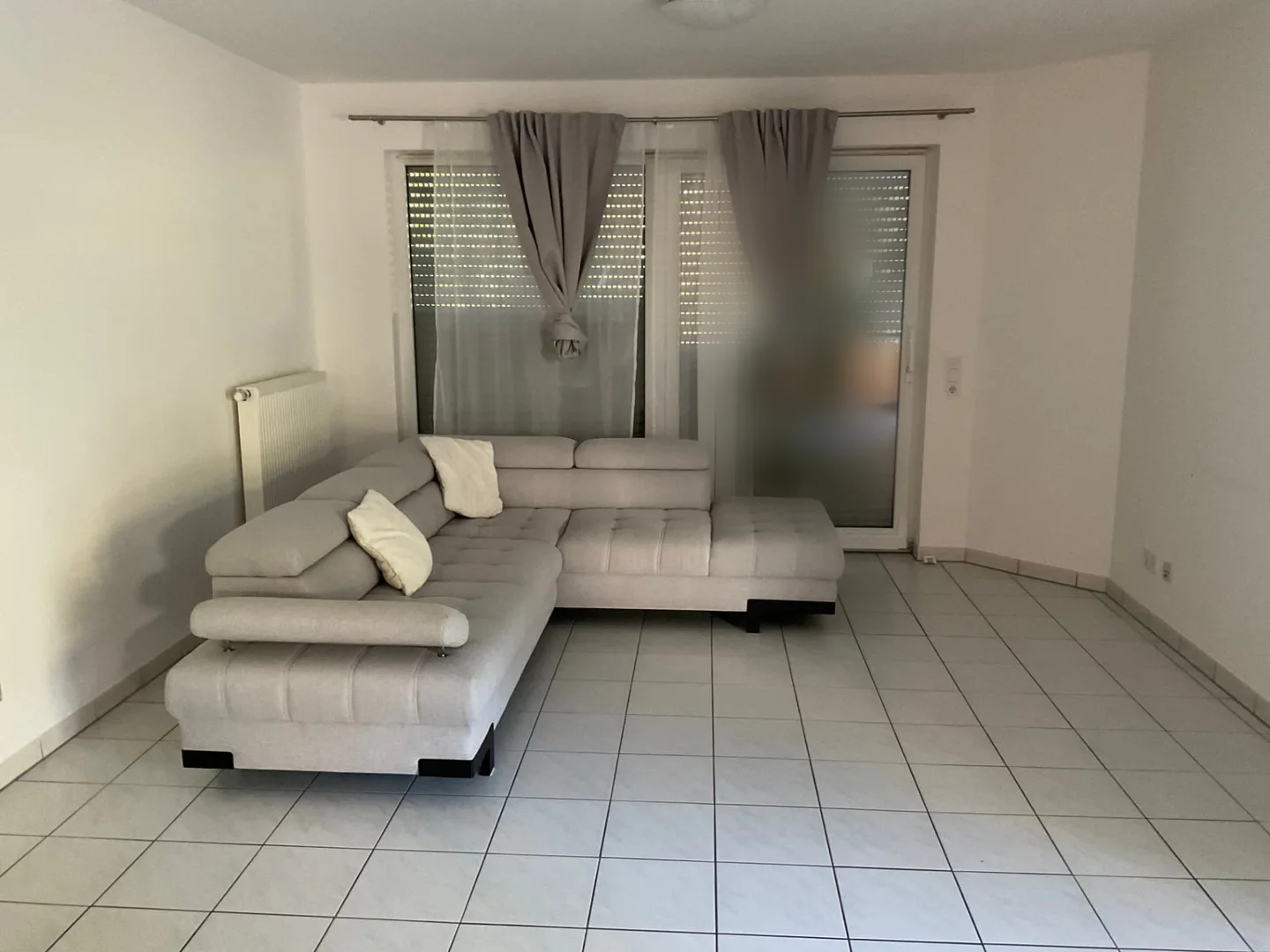 Wohnzimmer der Erdgeschosswohnung mit Sofa zu Beginn des Auftrags