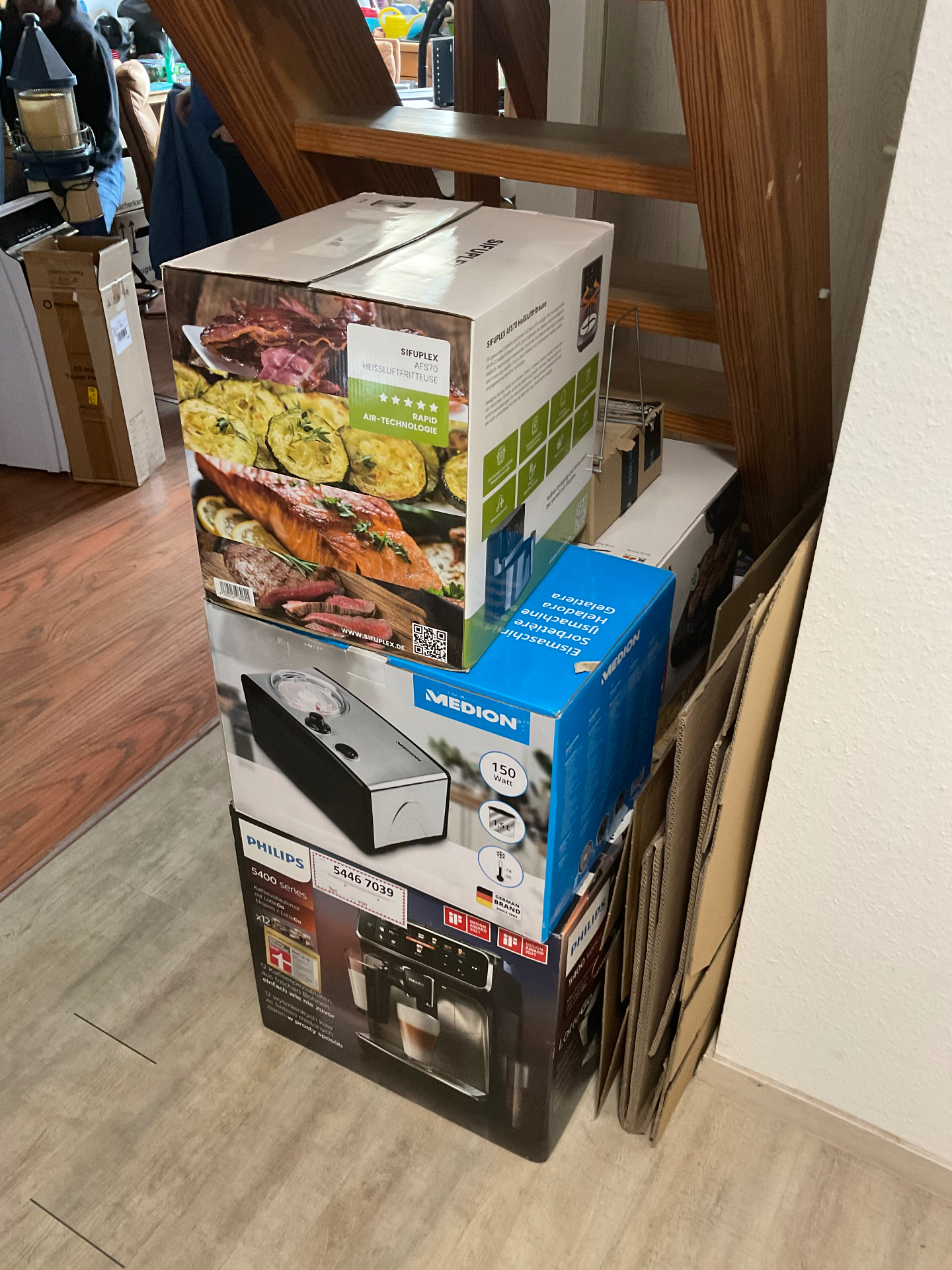 Kartonagen und Elektrogeräte unter der Treppe vor der Räumung